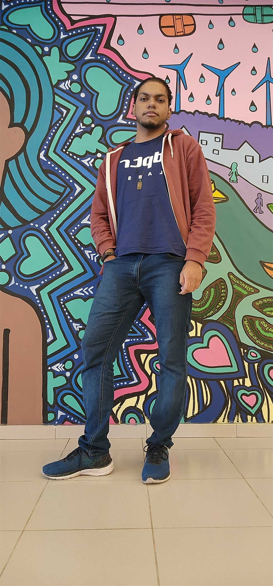 Tiago Danin, full length, in front of a mural